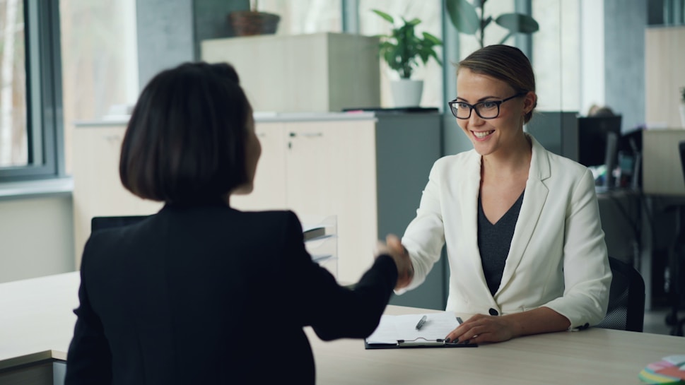 Two business professionals shaking hands in an office